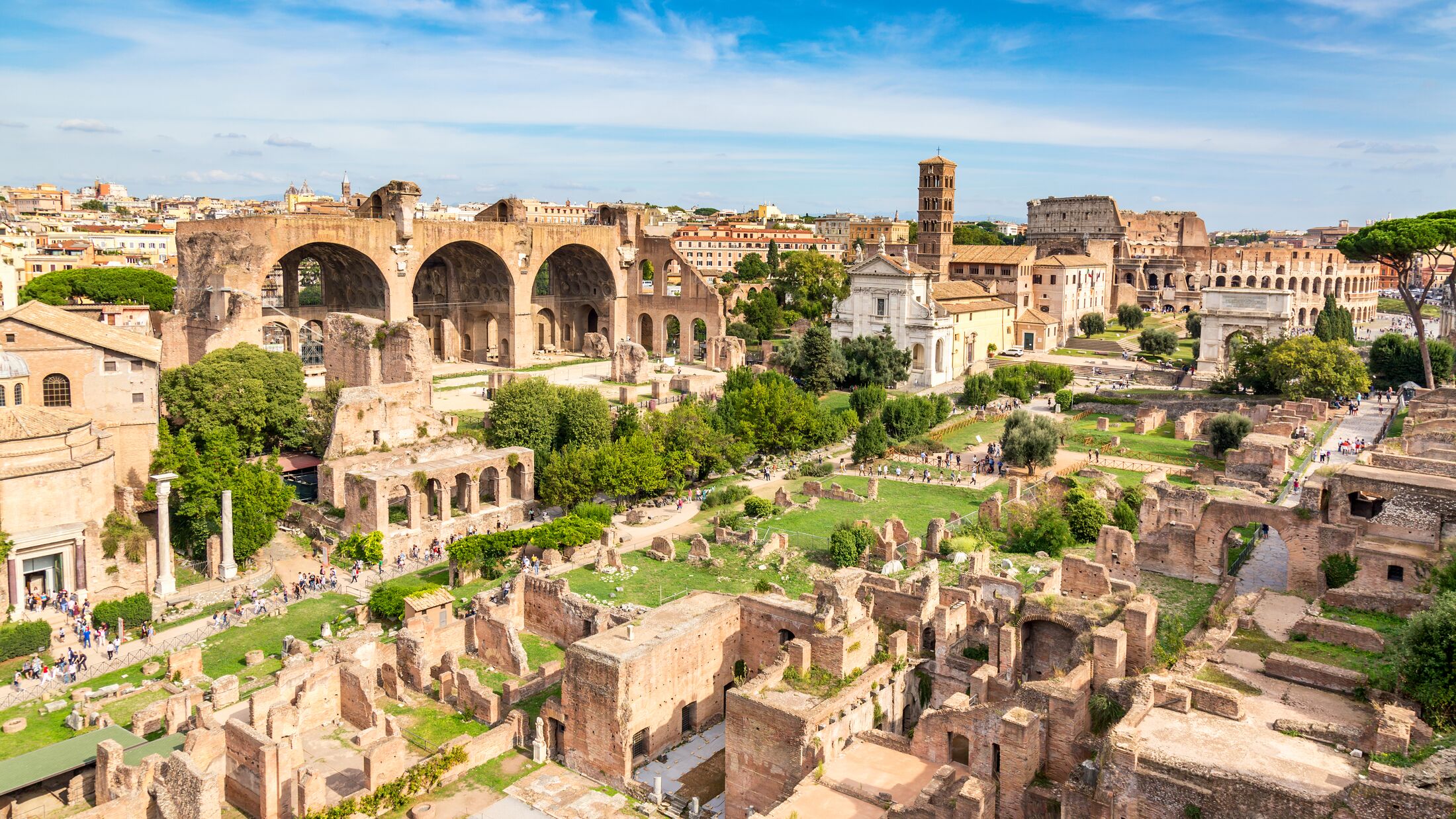Aerial panoramic cityscape view of the Roman Forum and Roman Colosseum in Rome, Italy. World famous landmarks in Italy during summer sunny day.