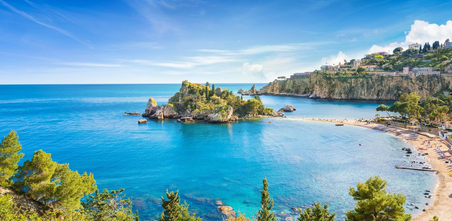 Panoramic view of Isola Bella small island near Taormina, Sicily, Italy. Narrow path connects island to mainland Taormina beach surrounded by azure waters of the Ionian Sea.