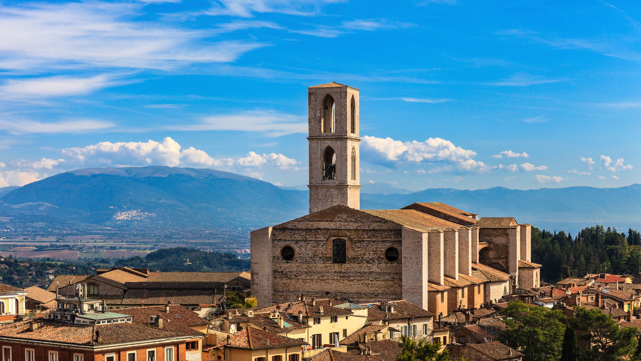 a tall clock tower with a mountain in the background