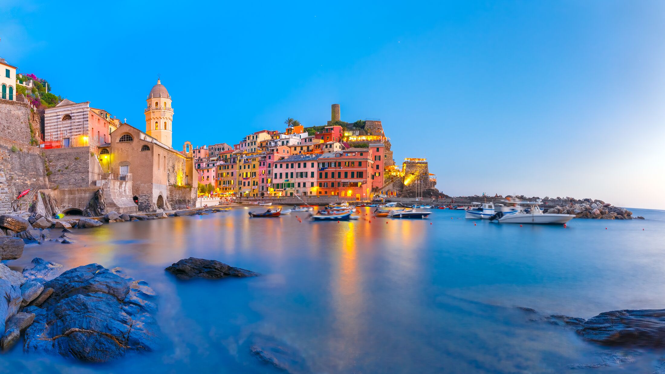 Panorama of night fishing village Vernazza with Santa Margherita di Antiochia Church and lookout tower of Doria Castle, Five lands, Cinque Terre National Park, Liguria, Italy.