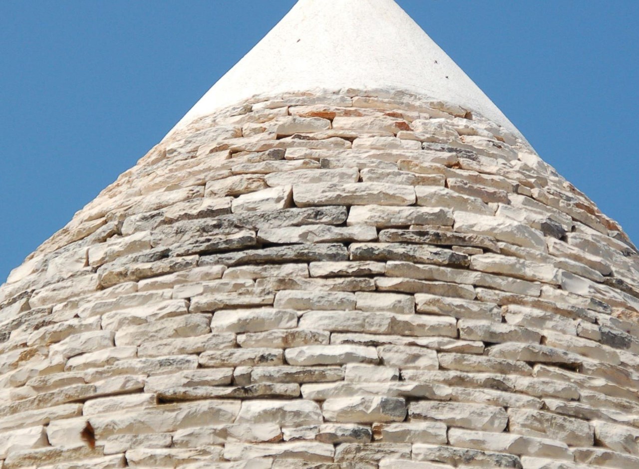 a large stone building with a mountain in the background