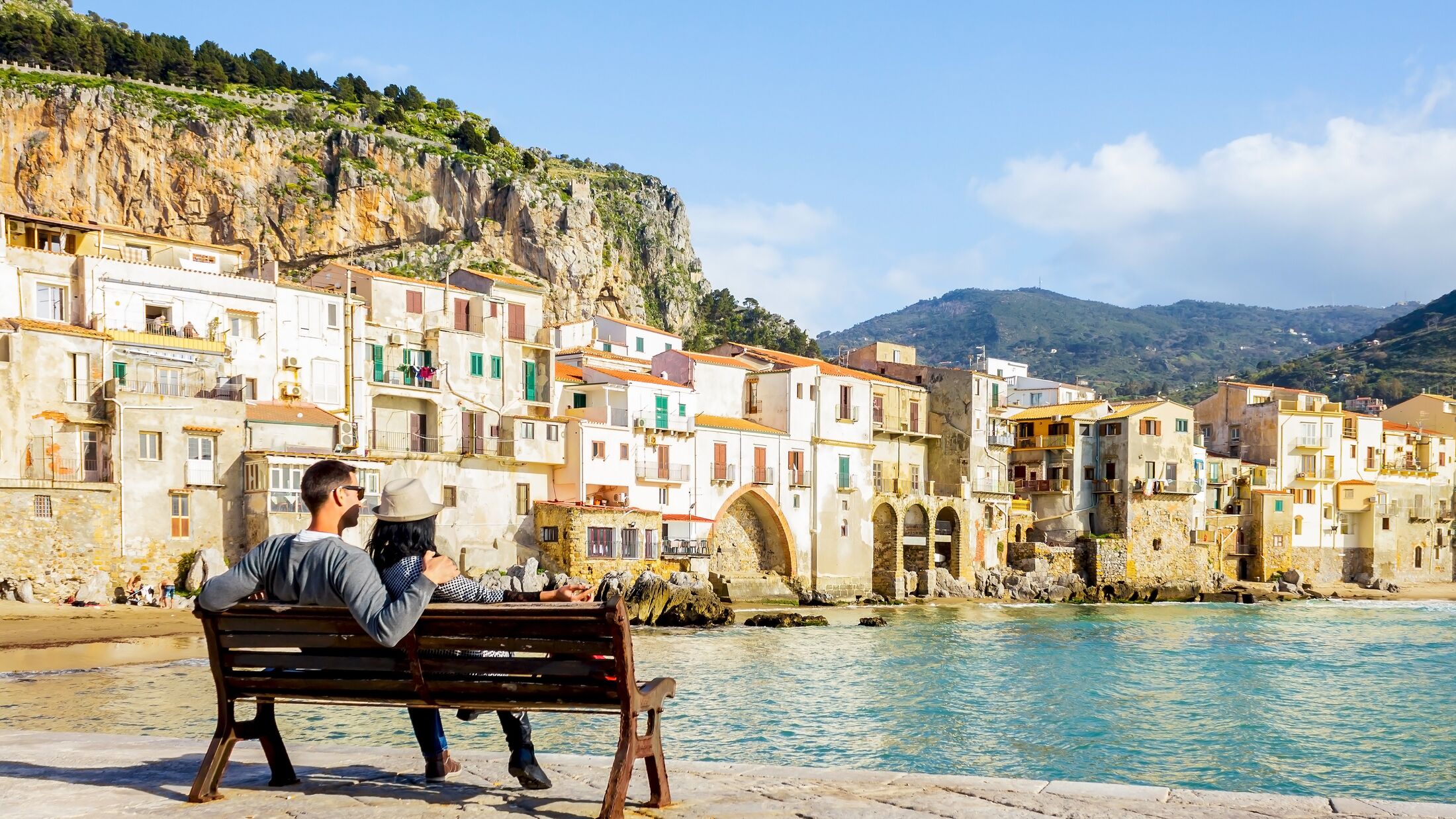 Couple on a bench overlooking Cefalu, Sicily