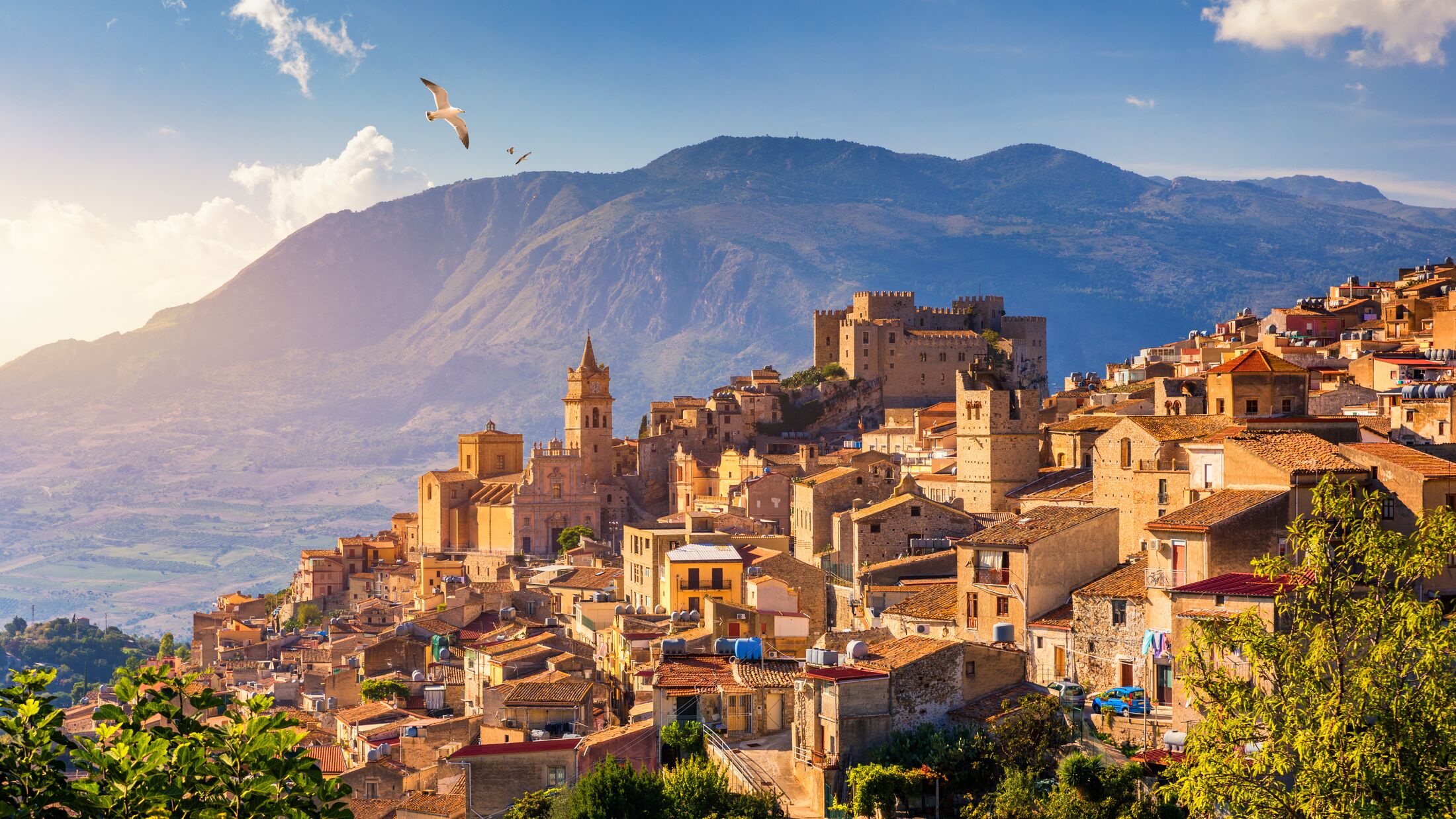 Caccamo, Sicily. Medieval Italian city with the Norman Castle in Sicily mountains, Italy. View of Caccamo town on the hill with mountains in the background, Sicily, Italy.