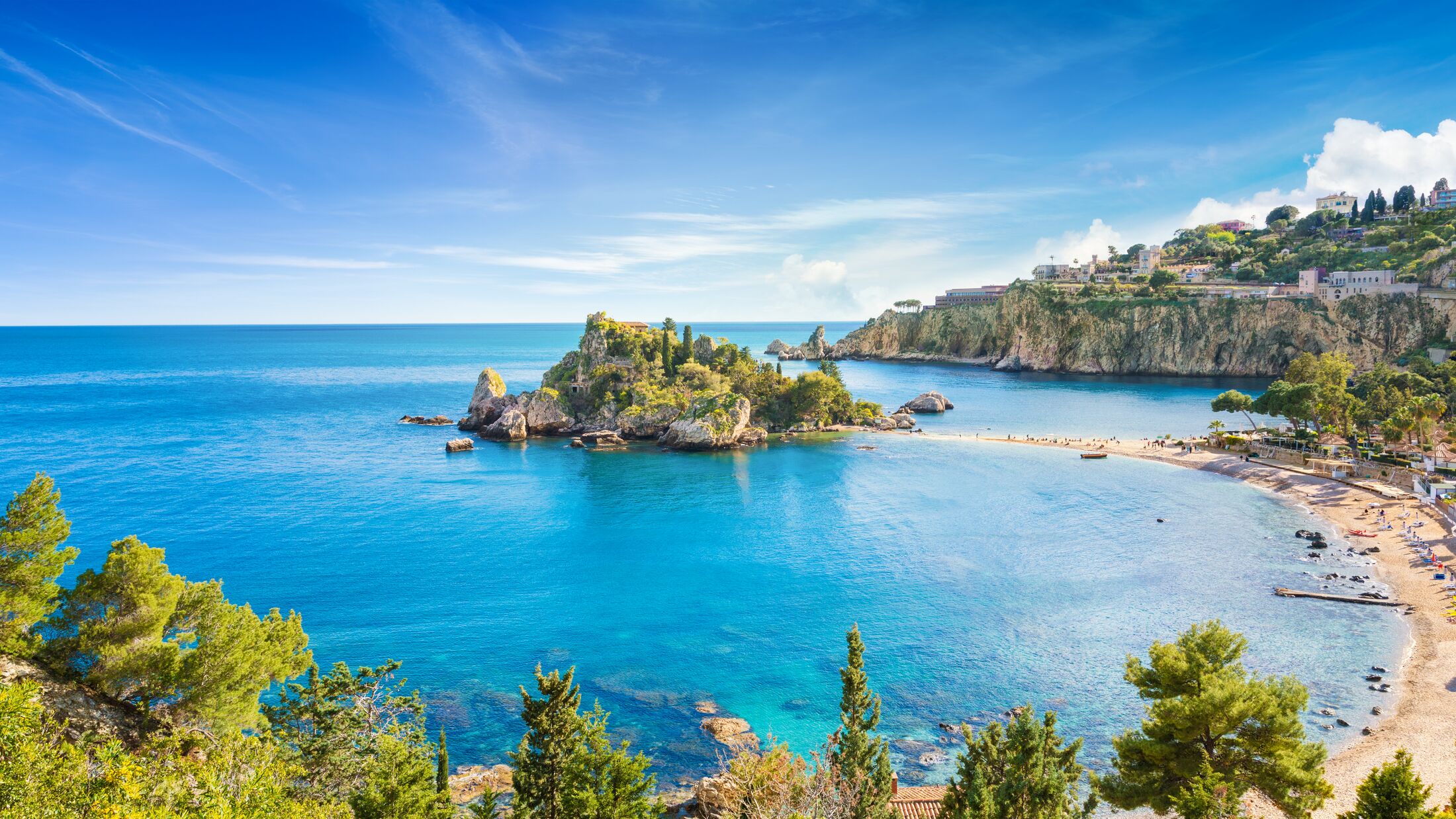 Panoramic view of Isola Bella small island near Taormina, Sicily, Italy. Narrow path connects island to mainland Taormina beach surrounded by azure waters of the Ionian Sea.