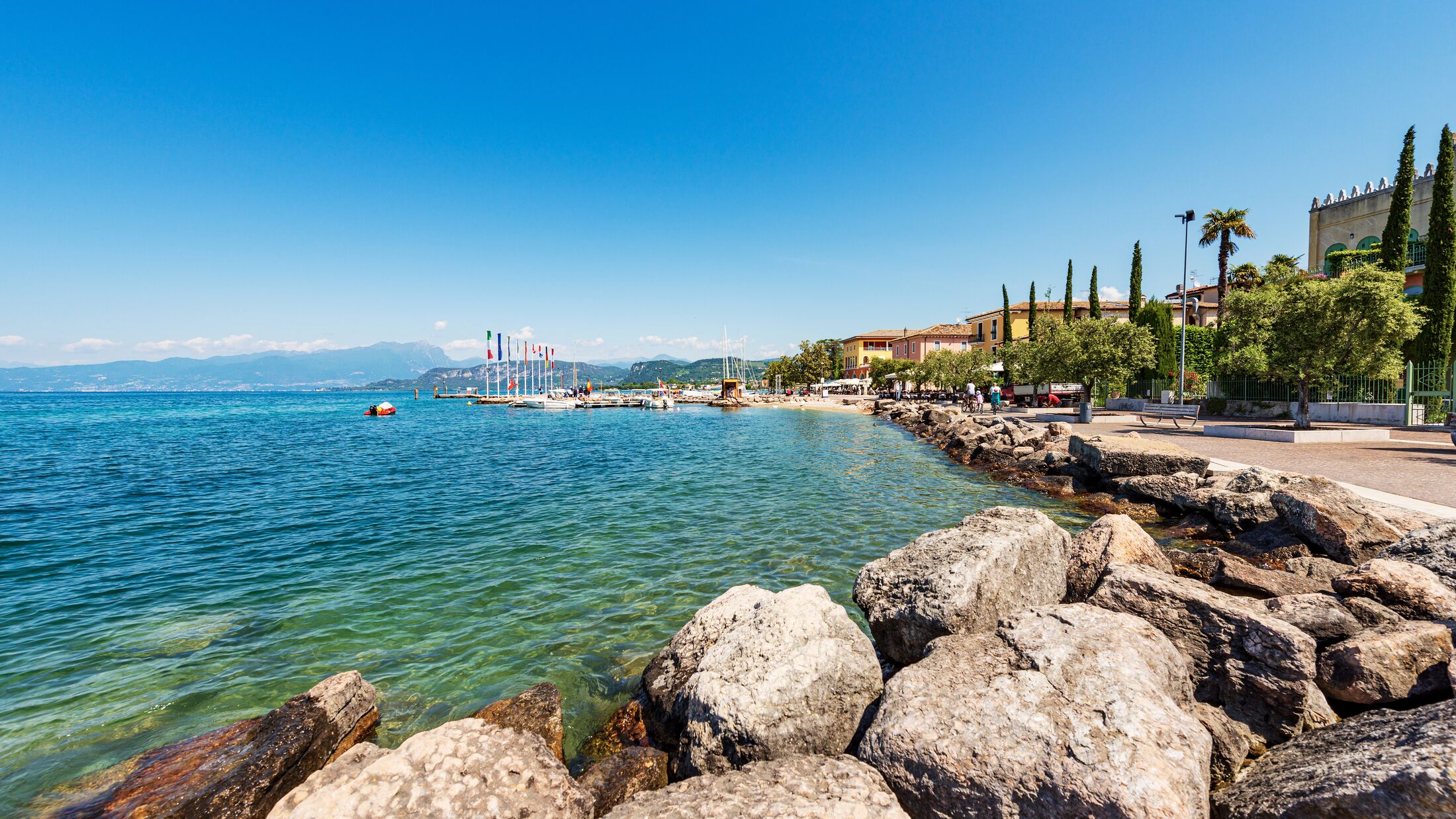 Lake Garda (Lago di Garda) and the small Village of Cisano di Bardolino with the port, tourist resort in Verona province, Bardolino municipality, Veneto, Italy, Europe. Lombardy coast on the horizon.