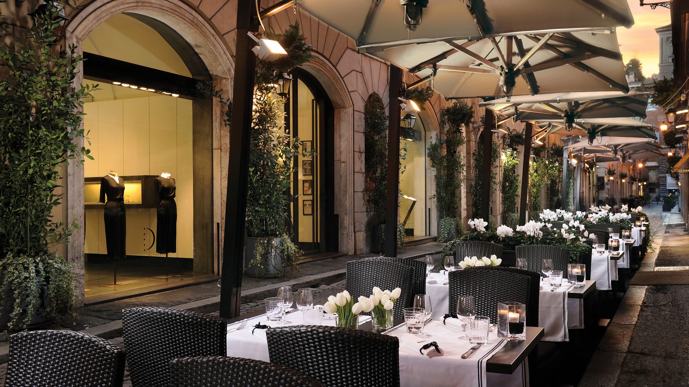 a group of people sitting at a table in front of a building