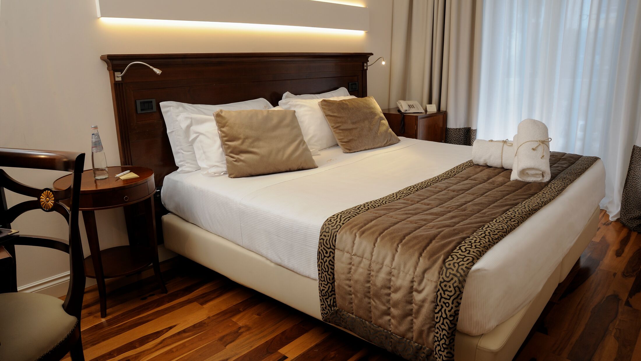 a bedroom with a bed and desk in a hotel room