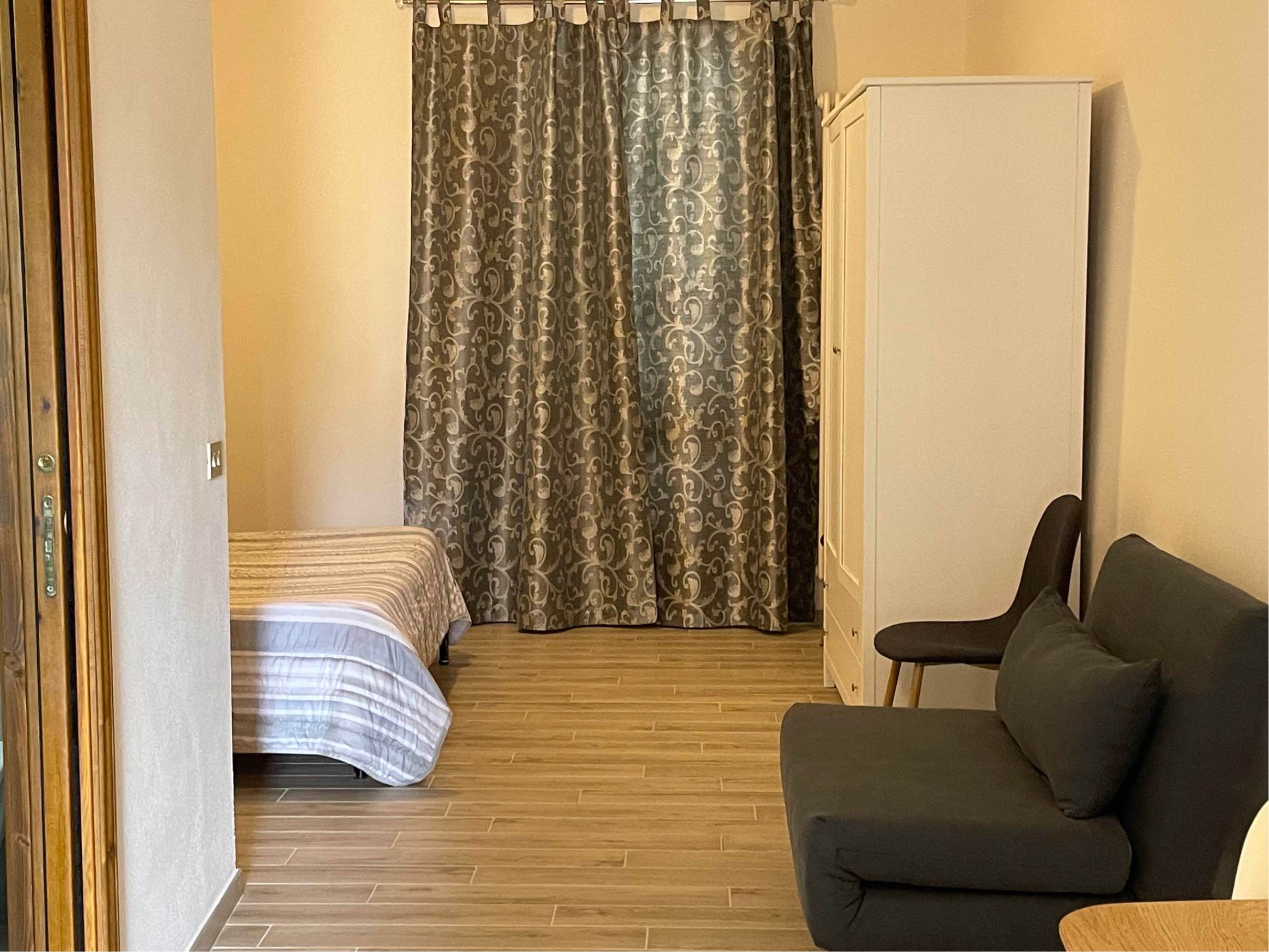 a chair sitting in front of a curtain