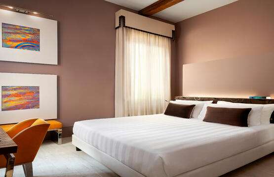 a bedroom with a bed and desk in a room