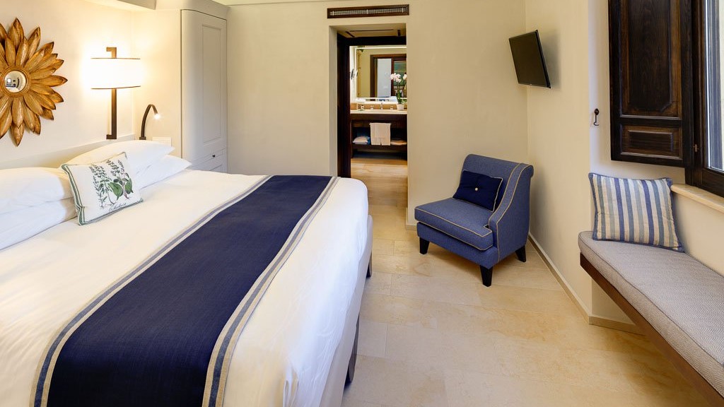 a bedroom with a bed and desk in a hotel room