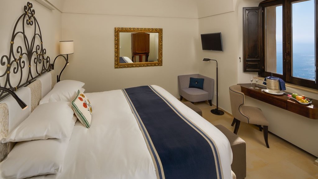 a bedroom with a bed and a mirror in a room