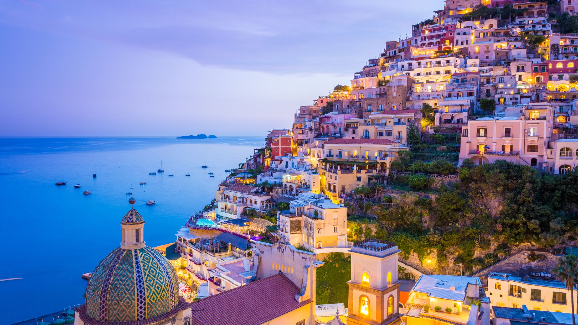 Positano, Amalfi Coast, Campania, Sorrento, Italy. View of the town and the seaside in a summer sunset