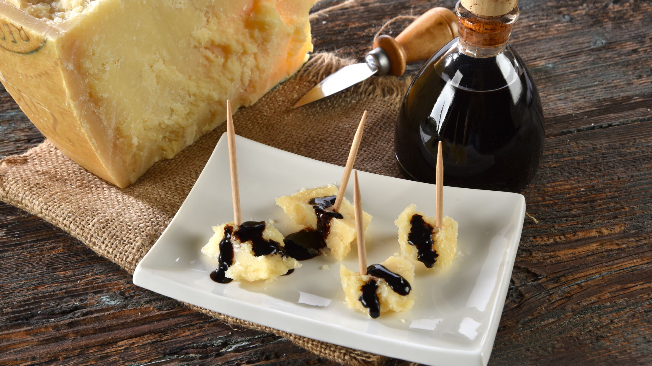 delight with Balsamic vinegar of Modena and Parmigiano Reggiano on a rustic table
