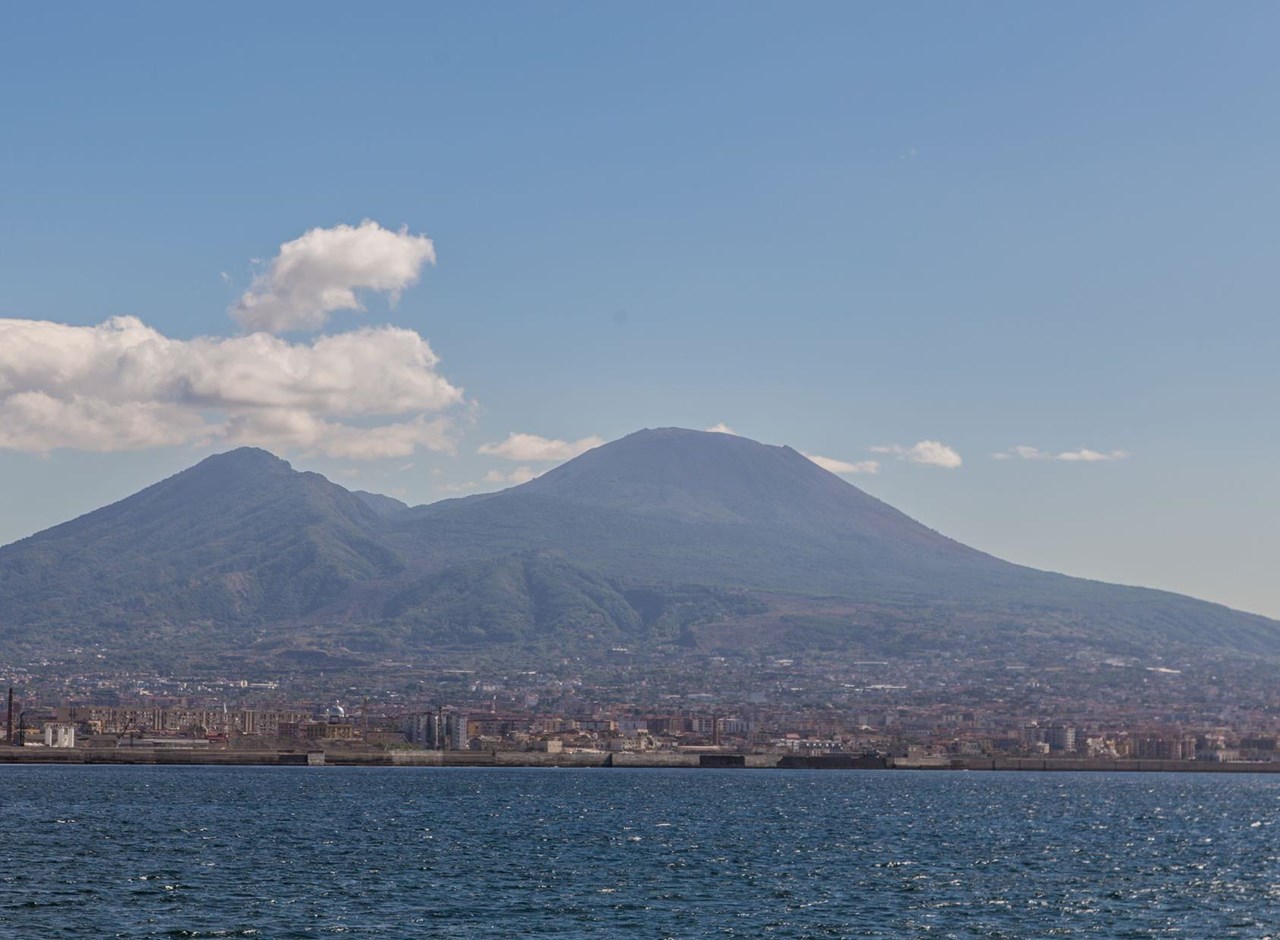 a large body of water with a mountain in the background