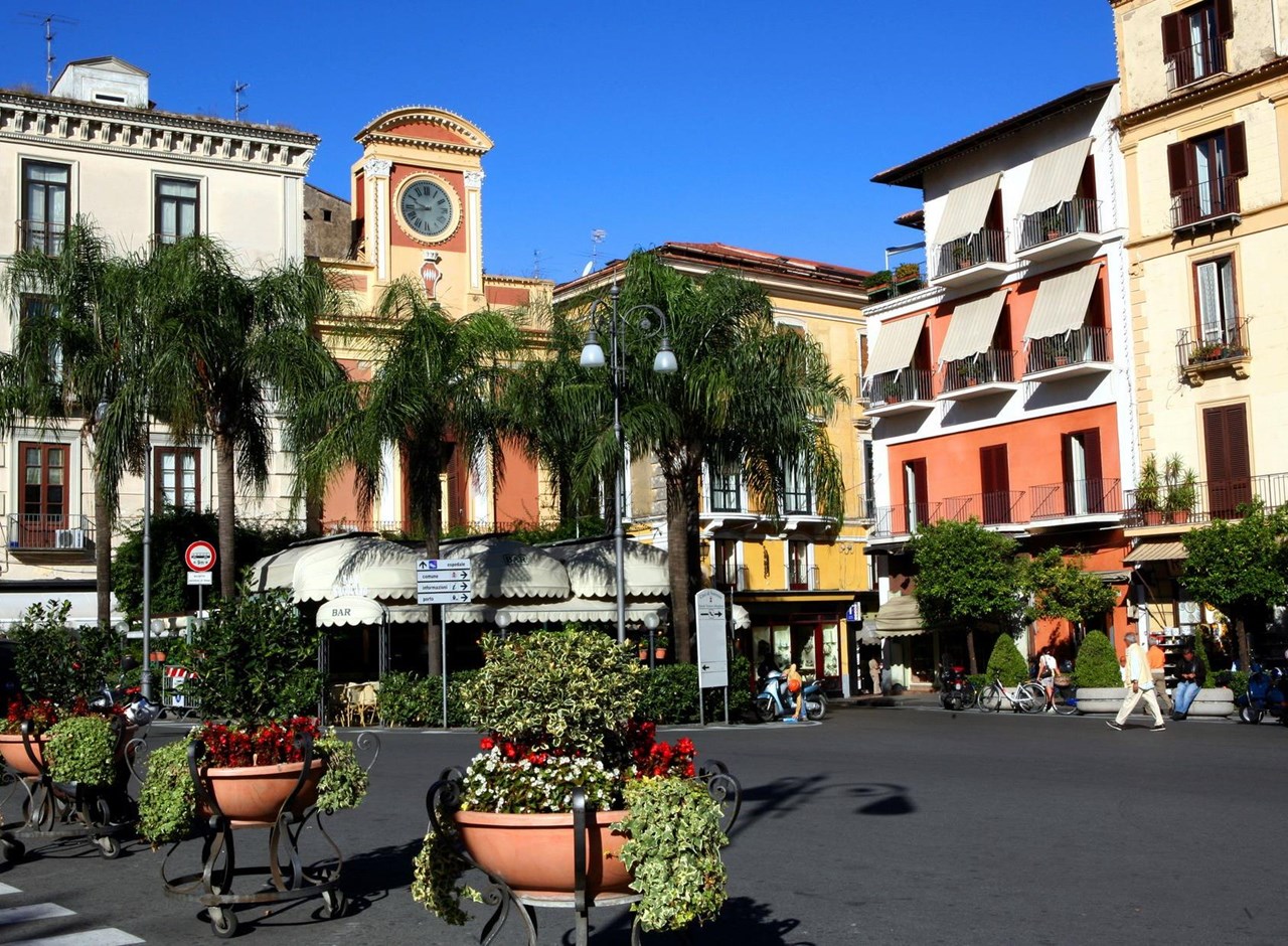 a close up of a street in front of a house with Piazza Tasso in the background