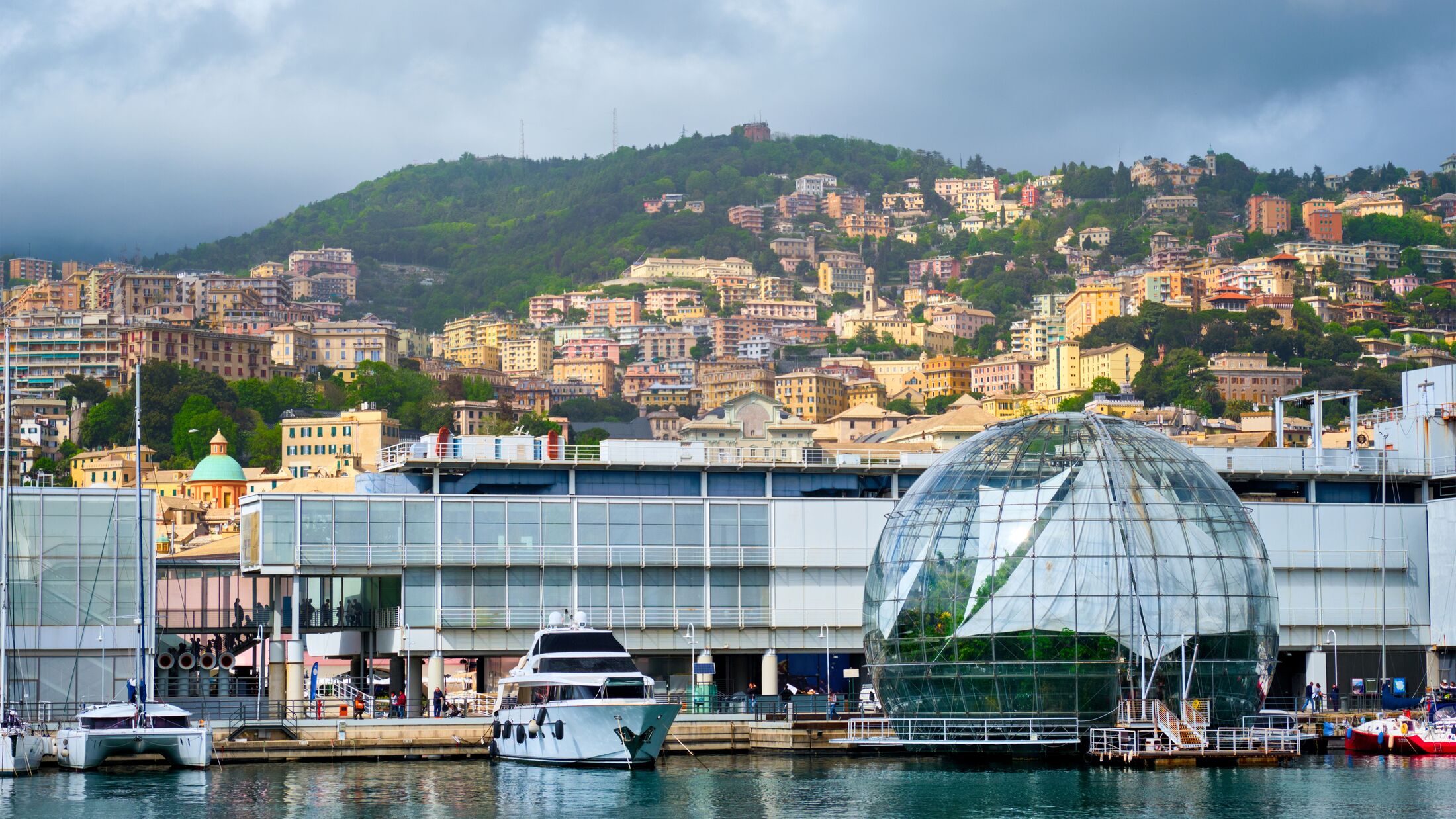 Old Port Porto Antico of Genoa (Genova) with yachts and boats with aquarium biosphere building under stormy sky. Genoa, Italy