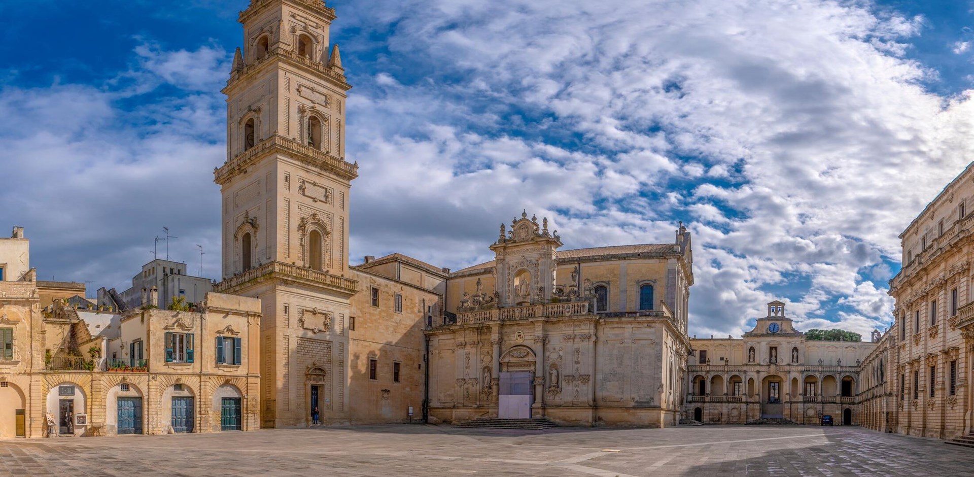 Panorama of Piazza del Duomo square , Campanile tower and Virgin Mary Cathedral ( Basilica di Santa Maria Assunta in Cielo ) , Caritas Diocesana in Lecce - Puglia, Italy. Baroque city of Apulia