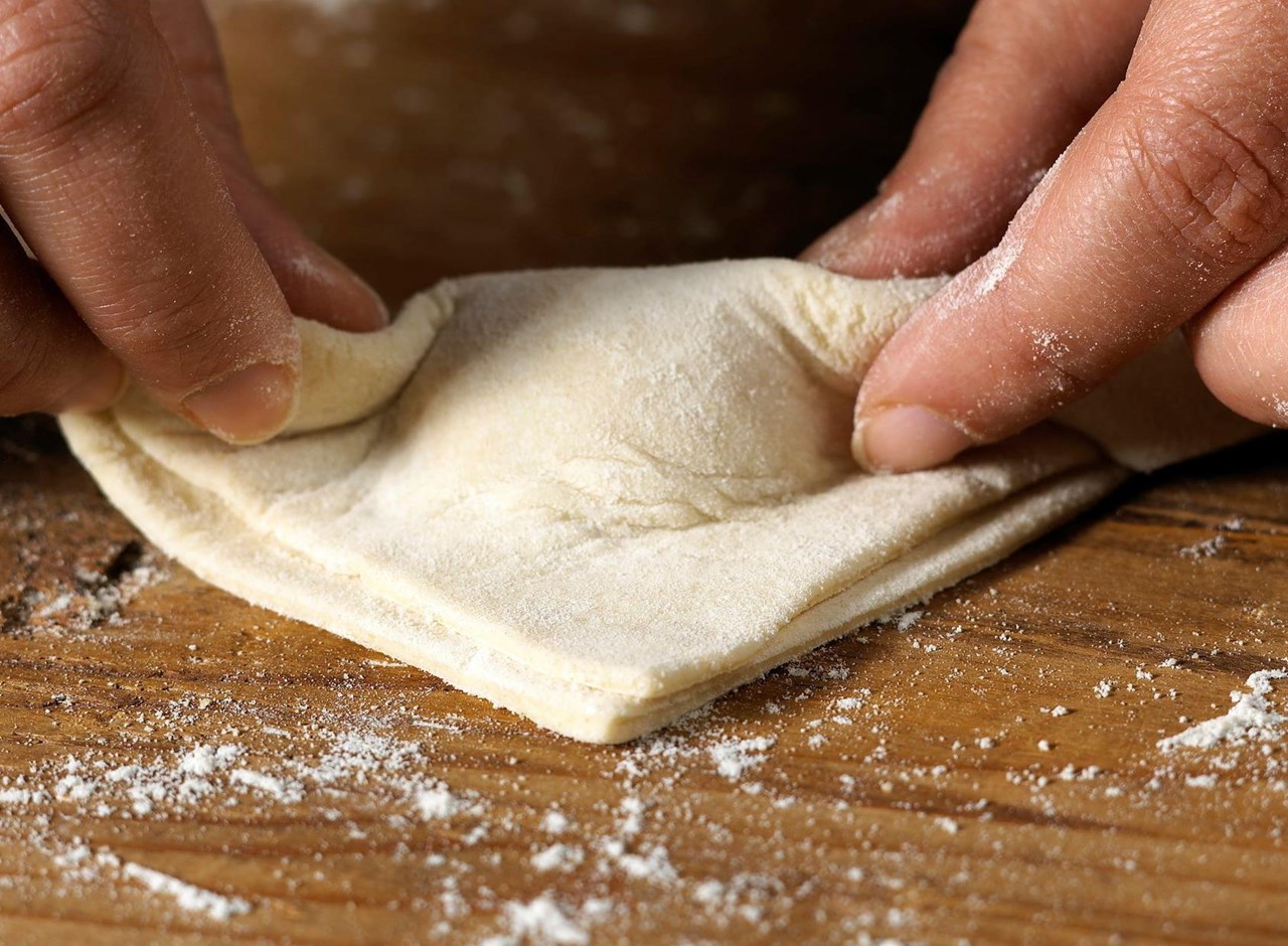 a close up of a person cutting a piece of bread