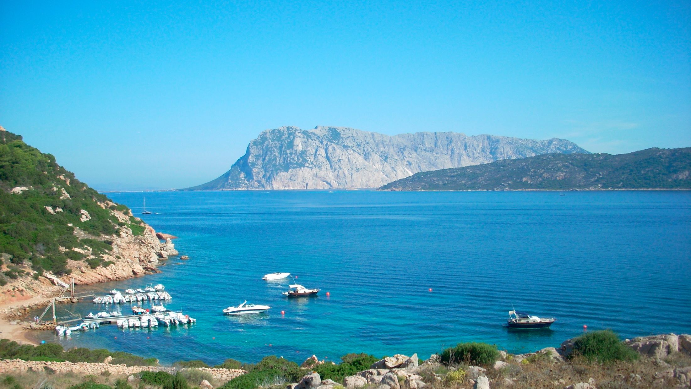 a large body of water with a mountain in the background