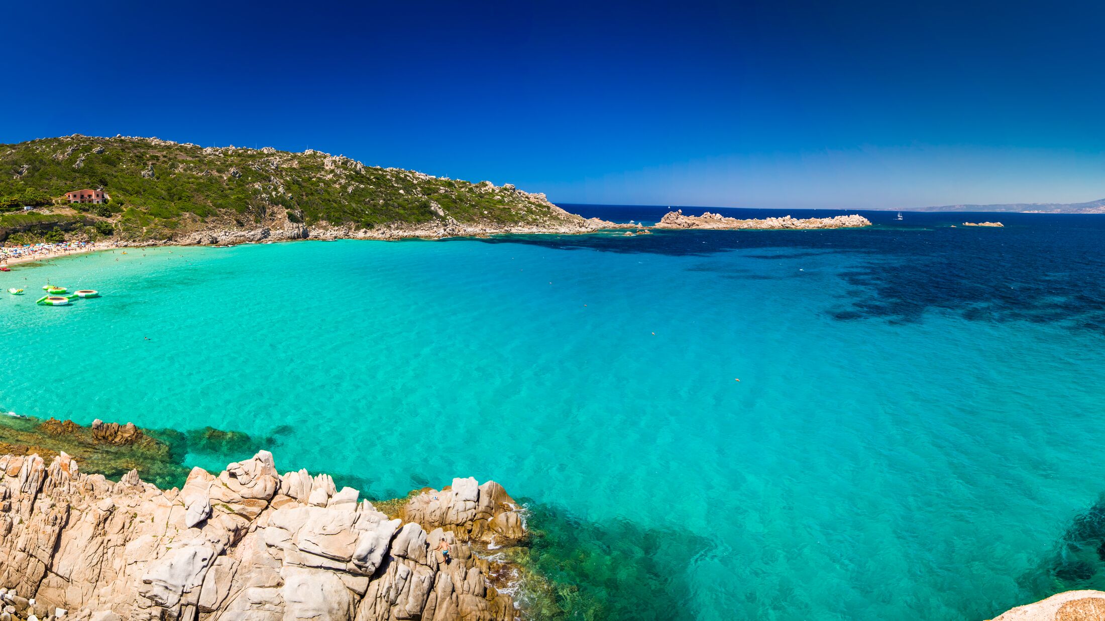 Spiaggia di Rena Bianca beach with red rocks and azure clear water, Santa Terasa Gallura, Costa Smeralda, Sardinia, Italy.