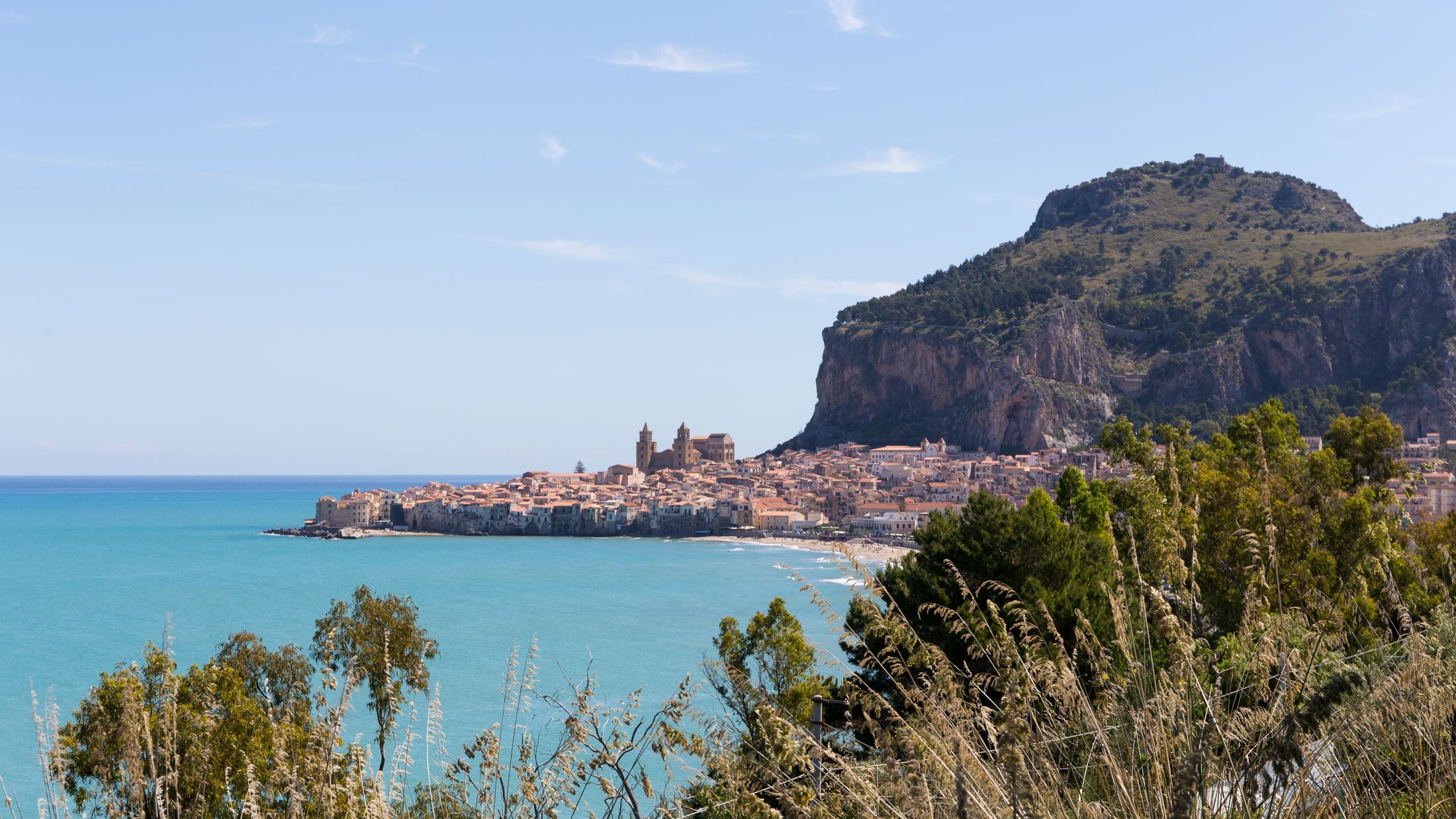 a large body of water with a mountain in the background