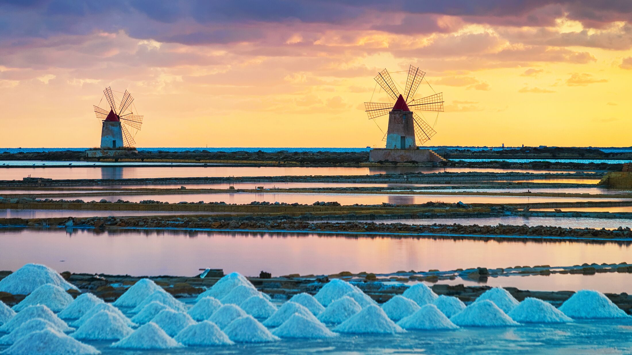 Sunset at Windmills in the salt evoporation pond in Marsala, Sicily island, Italy