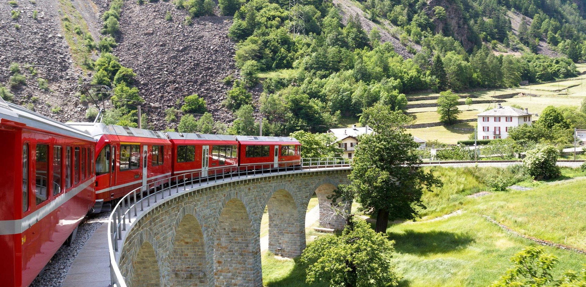 Swiss mountain train Bernina Express  passes the spiral of the Brusio Viaduct