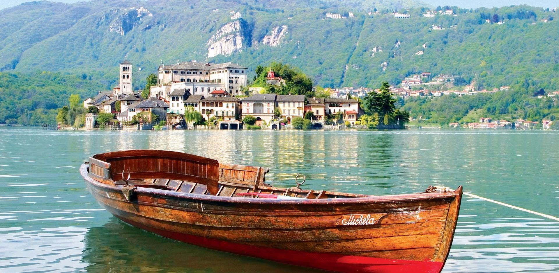 a small boat in a body of water with a mountain in the background