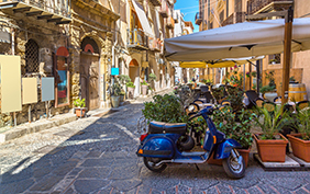 Narrow street in the old town of Cefalu in Sicily, Italy in a beautiful summer day