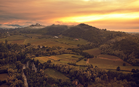 landscape of the stunning hillside of of Gavi, the famous wine village. In the background the sanctuary "Santuario della madonna della guardia" in the mist of the sunset, Piedmont, Italy.