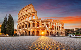 Rome, Italy at the Colosseum Amphitheater with the sunrise through the entranceway.