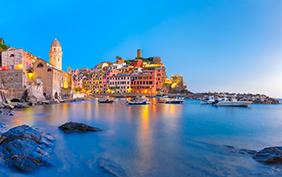 Panorama of night fishing village Vernazza with Santa Margherita di Antiochia Church and lookout tower of Doria Castle, Five lands, Cinque Terre National Park, Liguria, Italy.