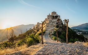 Stone village of Petralia Soprana,the highest village in Madonie mountain range,Sicily,Italy.Church of Santa Maria di Loreto at sunset.Picturesque stone houses,narrow cobbled streets,views of town