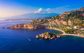 Taormina is a city on the island of Sicily, Italy. Mount Etna over Taormina cityscape, Messina, Sicily. View of Taormina located in Metropolitan City of Messina, on east coast of Sicily island, Italy.