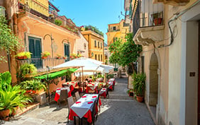 View of colorful narrow pedestrian street with cafe in old town Taormina. Sicily, Italy