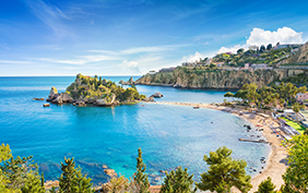 Panoramic view of Isola Bella small island near Taormina, Sicily, Italy. Narrow path connects island to mainland Taormina beach surrounded by azure waters of the Ionian Sea.