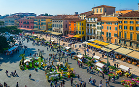 People are strolling among flower stands during Saturday market on the piazza bra in the Italian city Verona