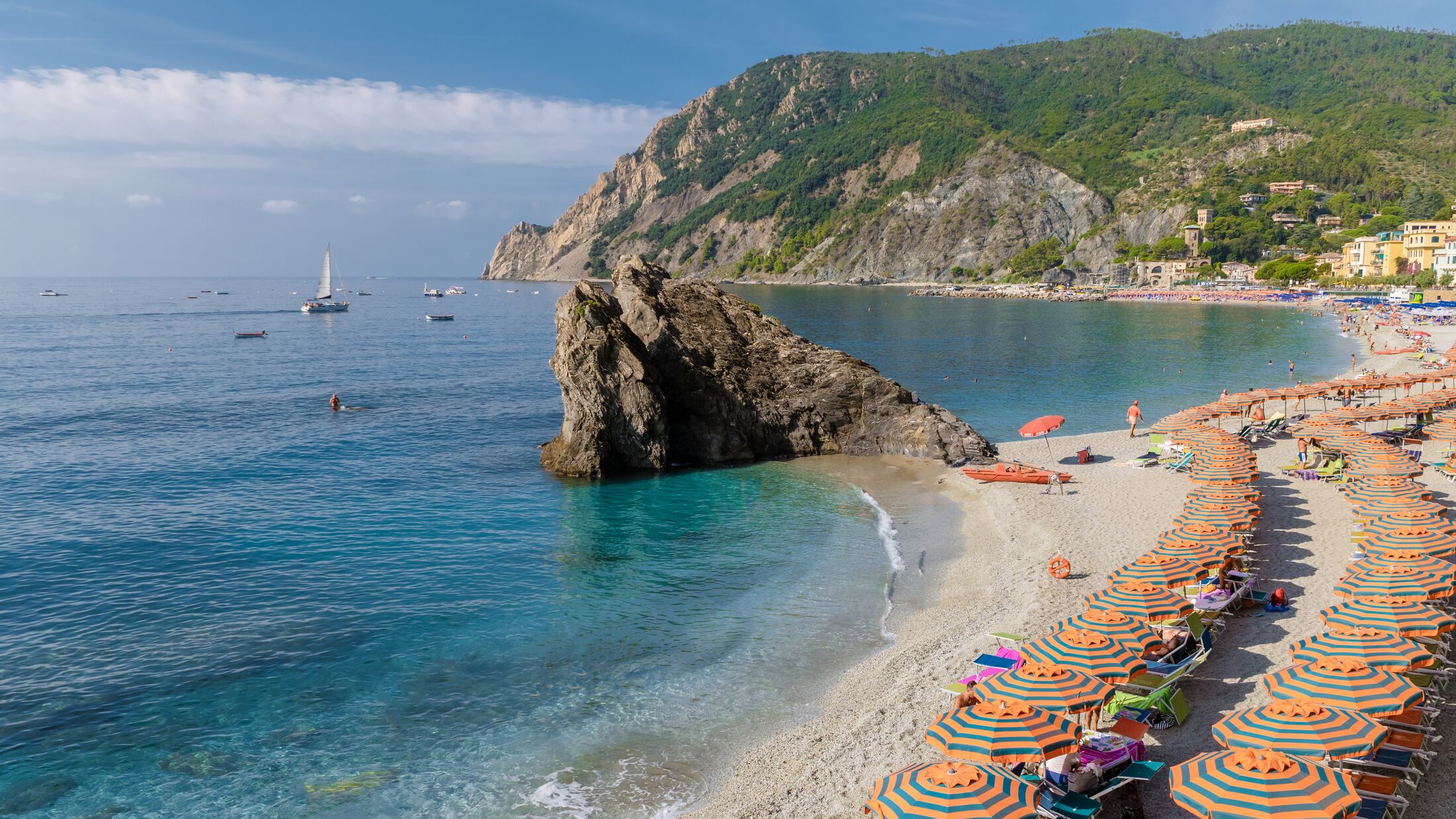 Pebble beach Monterosso vacation Cinque Terre Monterosso al Mare Chairs and umbrellas fill the Spiaggia di Fegina beach, Monterosso, part of the Cinque Terre Italy on a sunny day