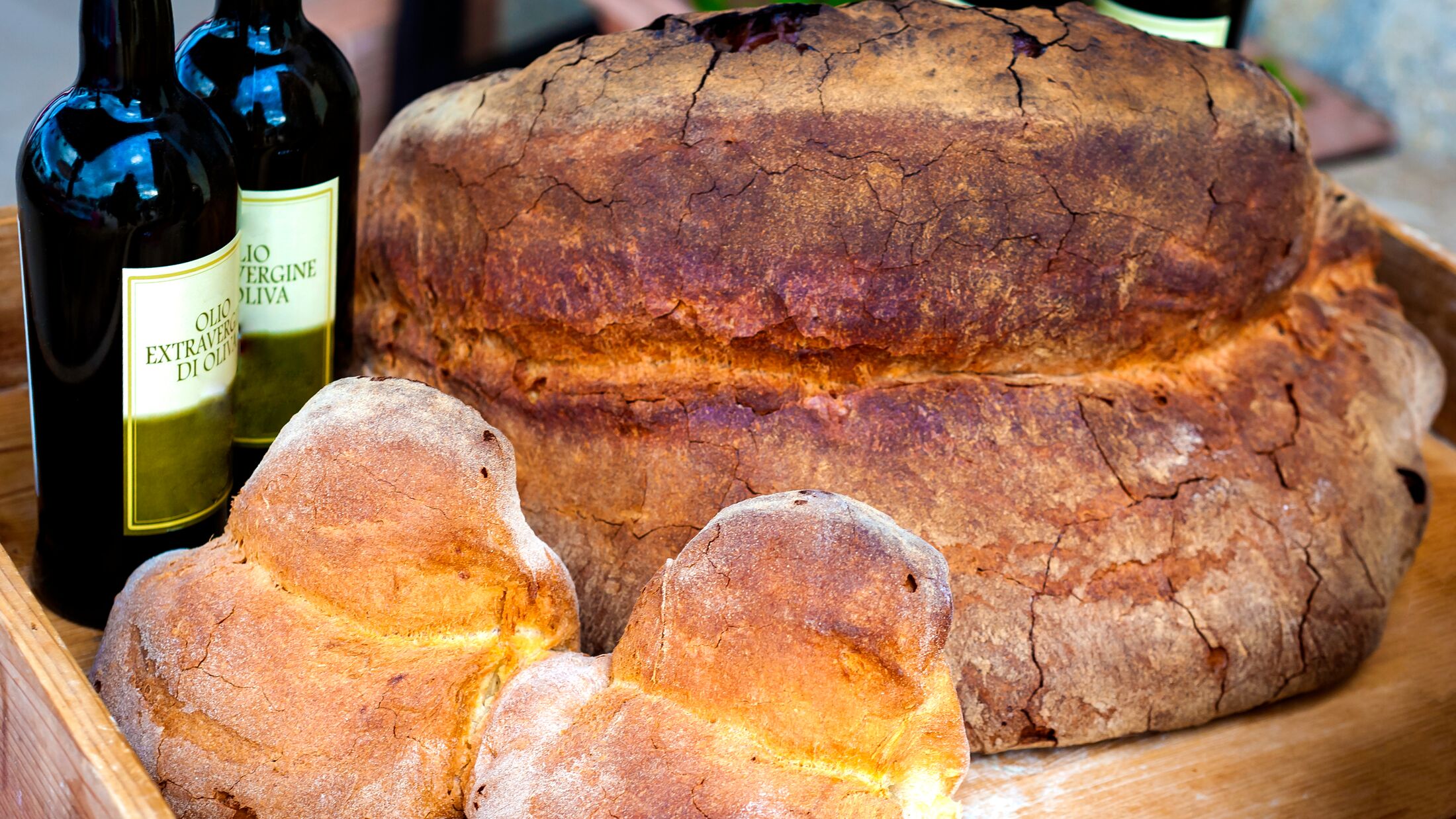 Display of Matera bread of different sizes, bottles with the indication of "Extra-virgin olive oil".