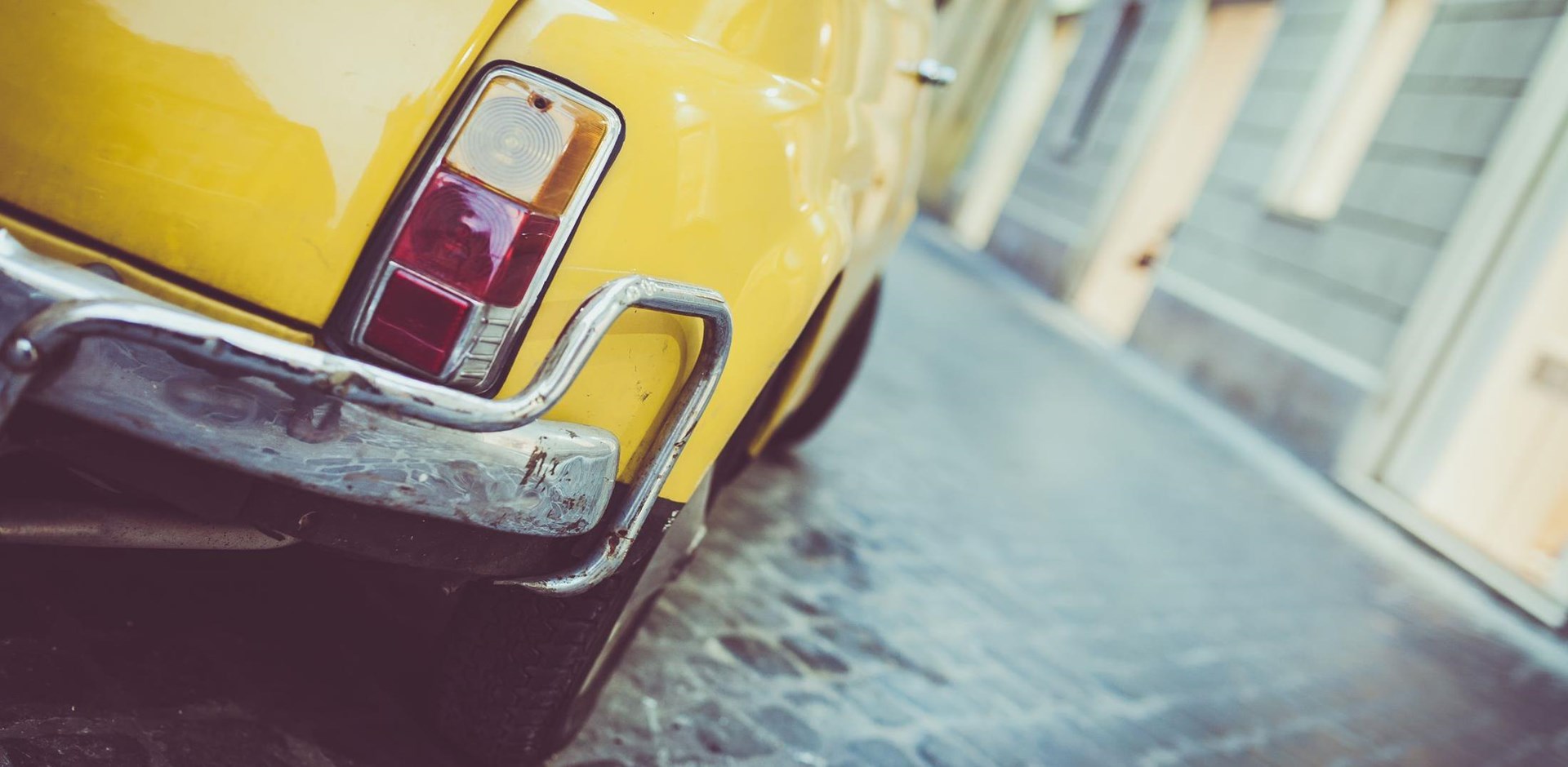 Rome, Italy - September 22, 2015: Closeup view of a yellow Fiat 500 parked in the historical centre of Rome. The Fiat 500 is a rear-engine, four passenger city car manufactured by Fiat Automobiles.; Shutterstock ID 499811389; PO: Project Italy - Facilities images; Job: Project Italy - Facilities images; Client: H&J/Citalia
