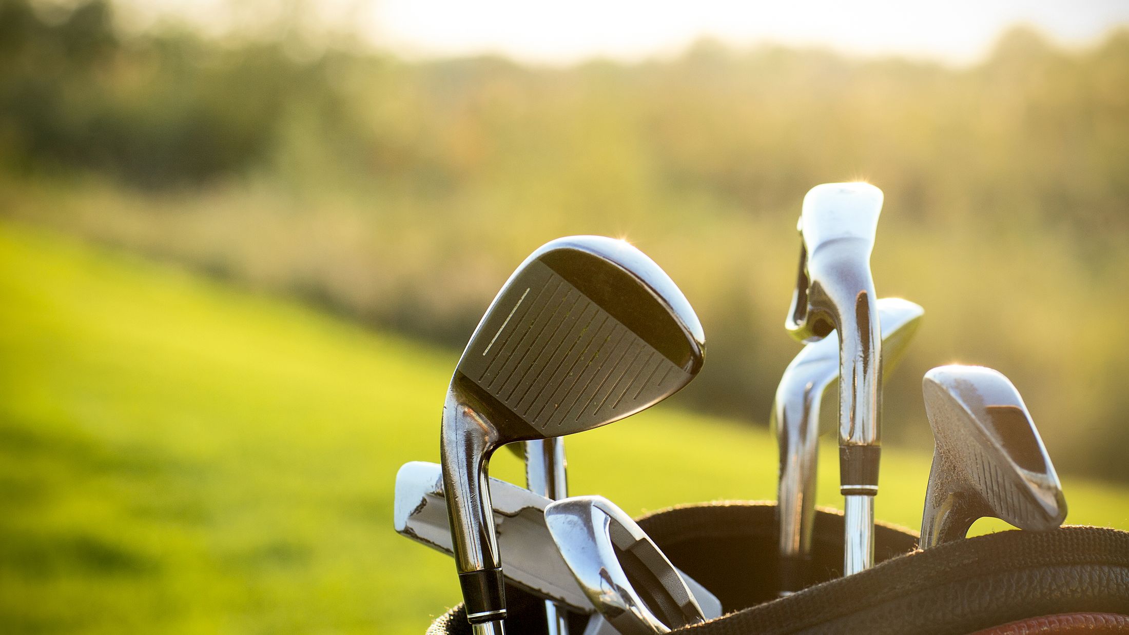 Golf clubs drivers over green field background. Summer sunset; Shutterstock ID 255601300; PO: Project Italy - Facilities images; Job: Project Italy - Facilities images; Client: H&J/Citalia