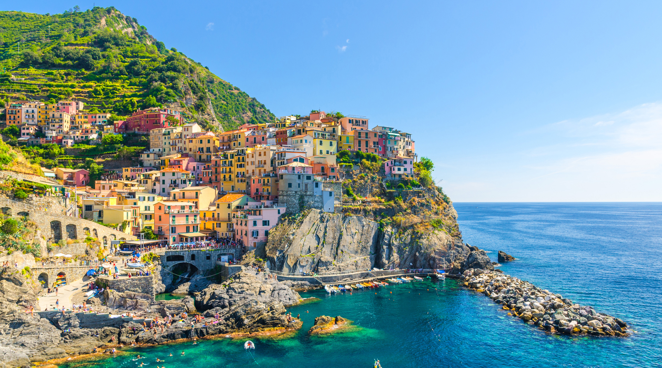 a body of water with Cinque Terre in the background