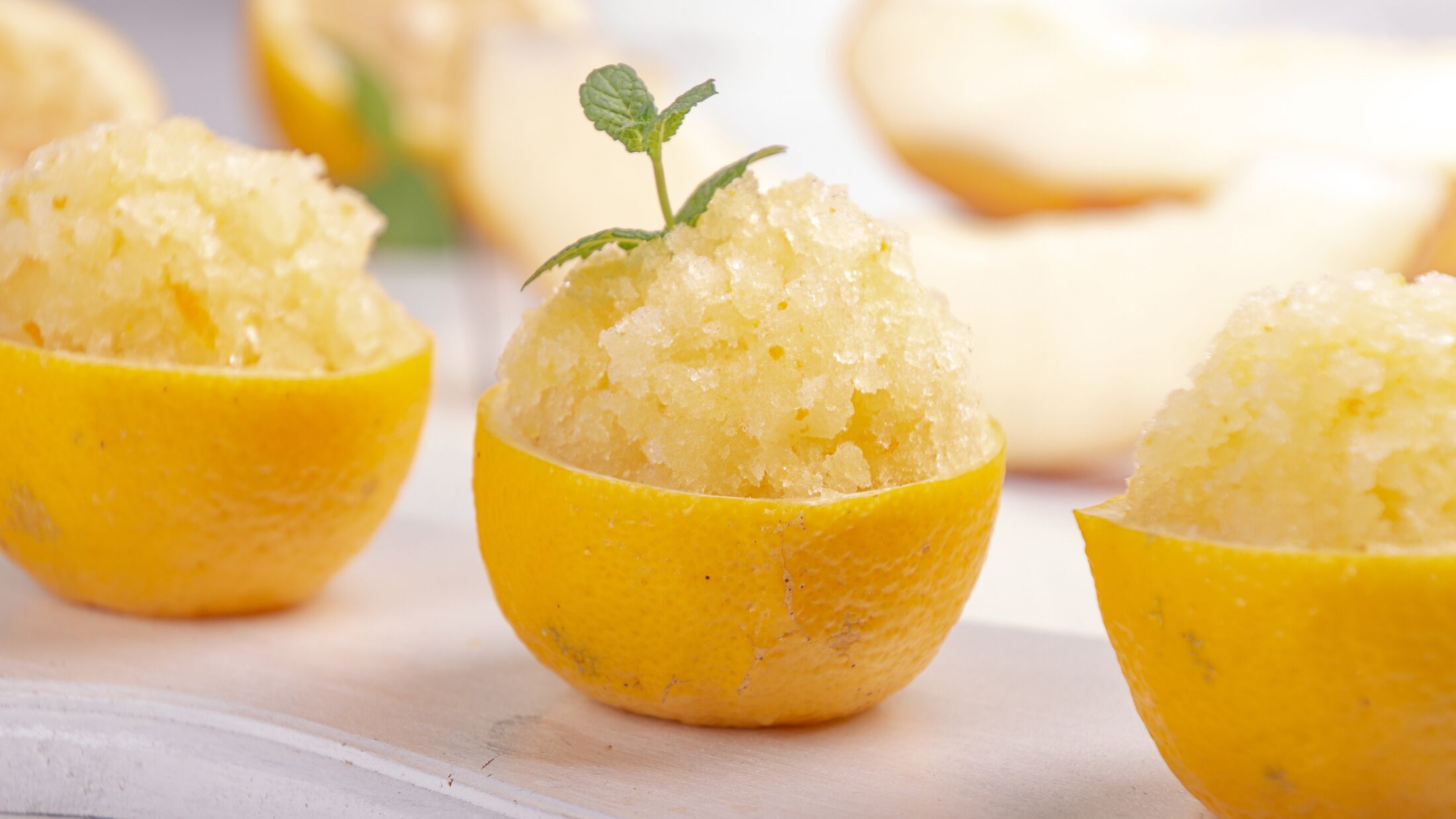 Melon and lemon fruit sorbet. Summer refreshing dessert in half of lemon fruit peel over on white background.